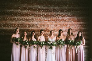 Bride posing with their bridesmaids while holding bouquets